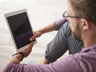 Man on tablet pays for e-commerce transaction with smartphone and credit card