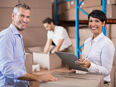 Frau und Mann lächeln bei der Arbeit im Warehousing | Mail Boxes Etc.